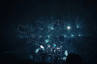 Digital light cubes suspended in a dark space with glowing beams and abstract visuals.